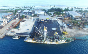A purse seiner at the PII dock gets repairs made to its fishing net. Photo: PII