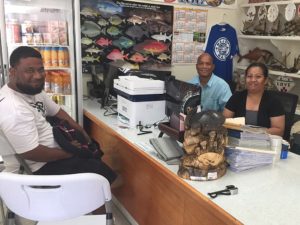 Customer Nibaan Edwin with administrators Arlington Tibon and Angelina Joses. Photo: Karen Earnshaw