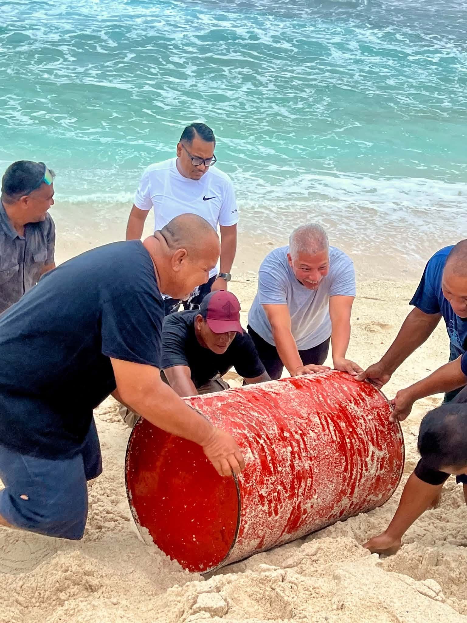 Kili Island, Christmas 2025 — a group rolling a barrel along the beach
