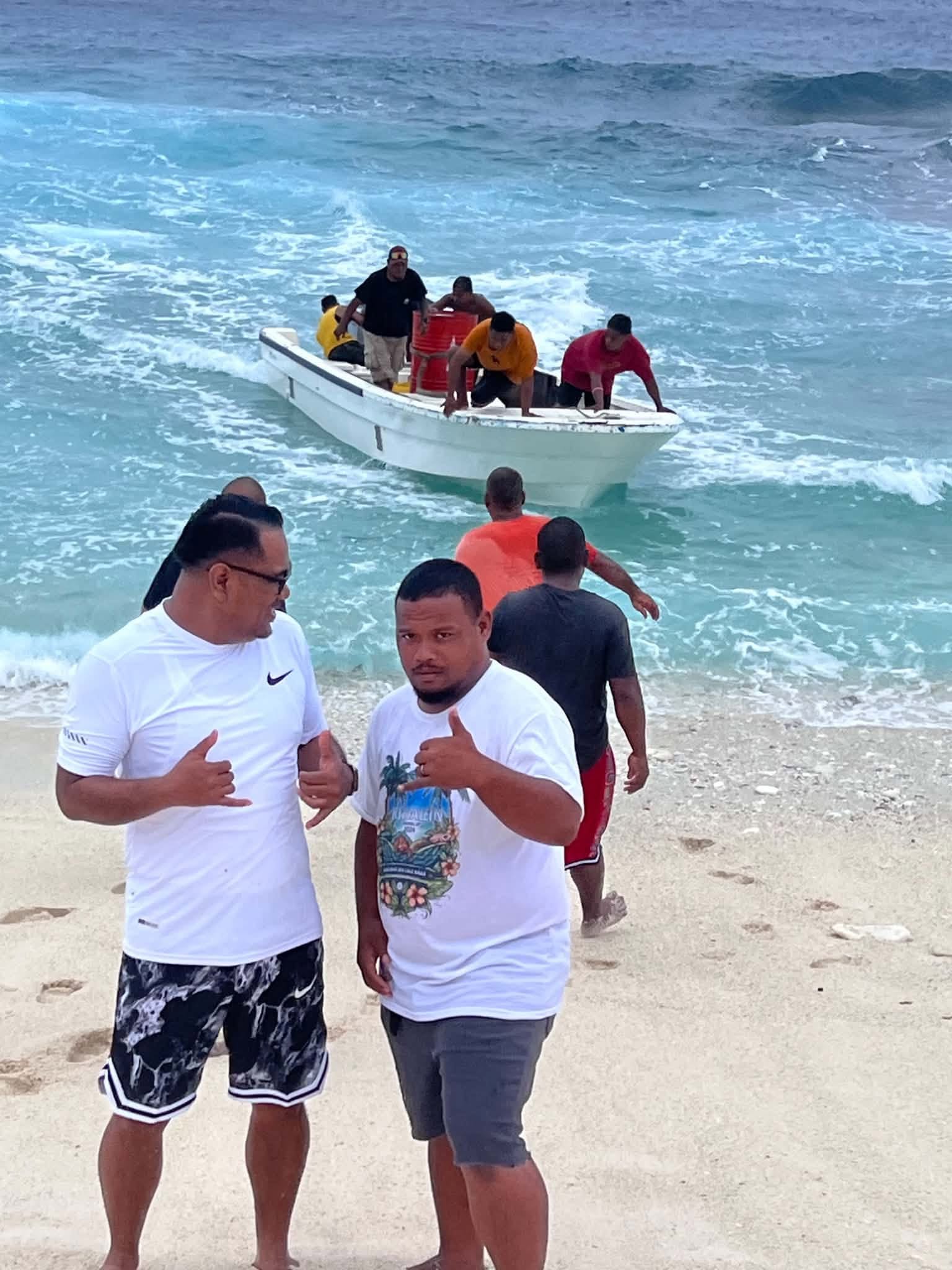 Kili Island, Christmas 2025 — two men on the beach with the boat crew behind them