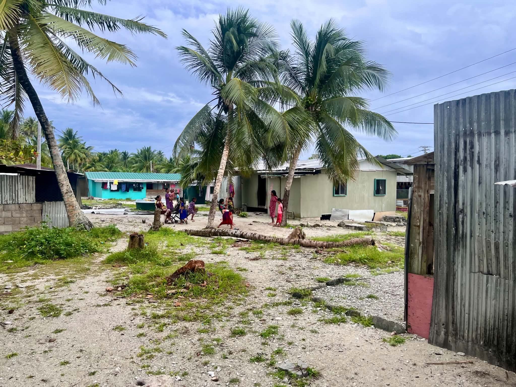 Kili Island, Christmas 2025 — a village scene with palm trees and children playing