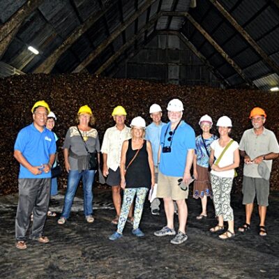 The Laura tour group poses with a mountain of copra. Photo: Karen Earnshaw