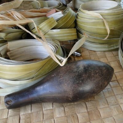 A weaver's pounder and 'maan' (dried pandanus), which she will use to make a 'jaki-ed' (clothing mat).