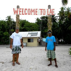 Kevin Battams-Akast and friend under the Lae sign. Photo: Will Lathrop