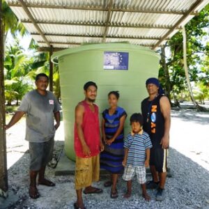 A Lae family poses with their new water catchment. Carpenter Jeffrey Andaya is at left. Photo: Dustin Langidrdik