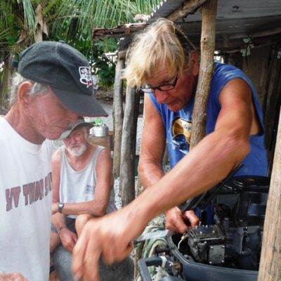 Cruisers Larry Jones and Pete Allen try and fix an outboard in NW Mili. Photo: James McCarthy