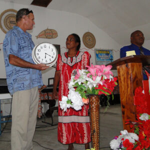 Cary Evarts presents a clock to Emily and Anious Kaious for their church. Photo: Karen Earnshaw