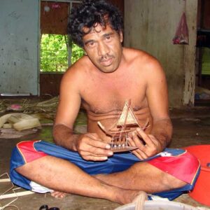 Kidzhey Helies shows off a small canoe he crafted.