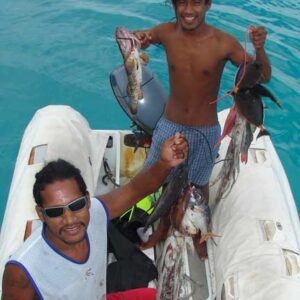 Fredly, Taylor (left), and Calvin fishing on the outer reef from Seal's dinghy