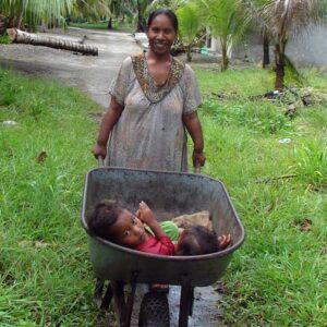 A mother uses a wheelbarrow to take her children home.